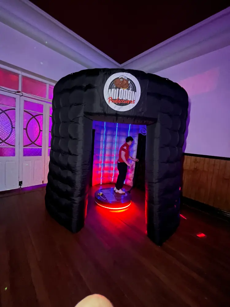 Cabina espejada con el logo de Milodón y una invitada posando adentro